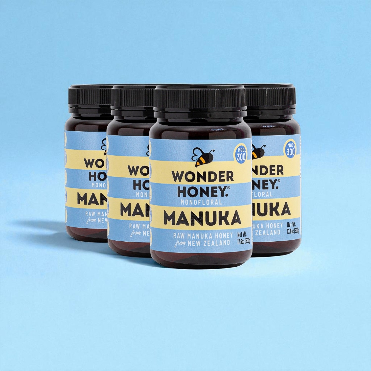 Four jars of Wonder Honey Manuka honey on a blue background