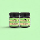 Two jars of Wonder Honey Manuka honey on a green background