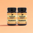 Two bottles of Wonder Honey Manuka honey on a peach background