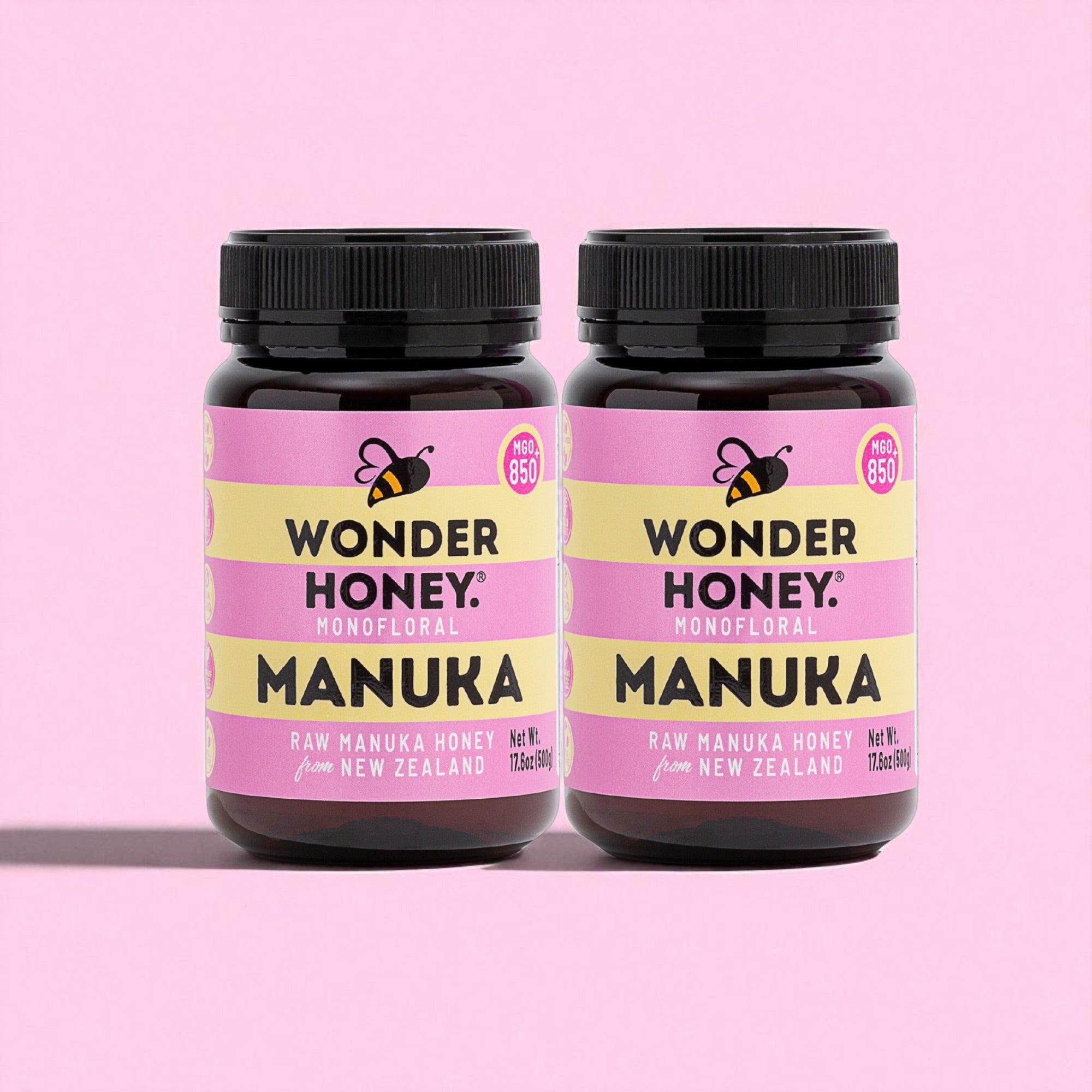Two jars of Wonder Honey Manuka honey on a pink background