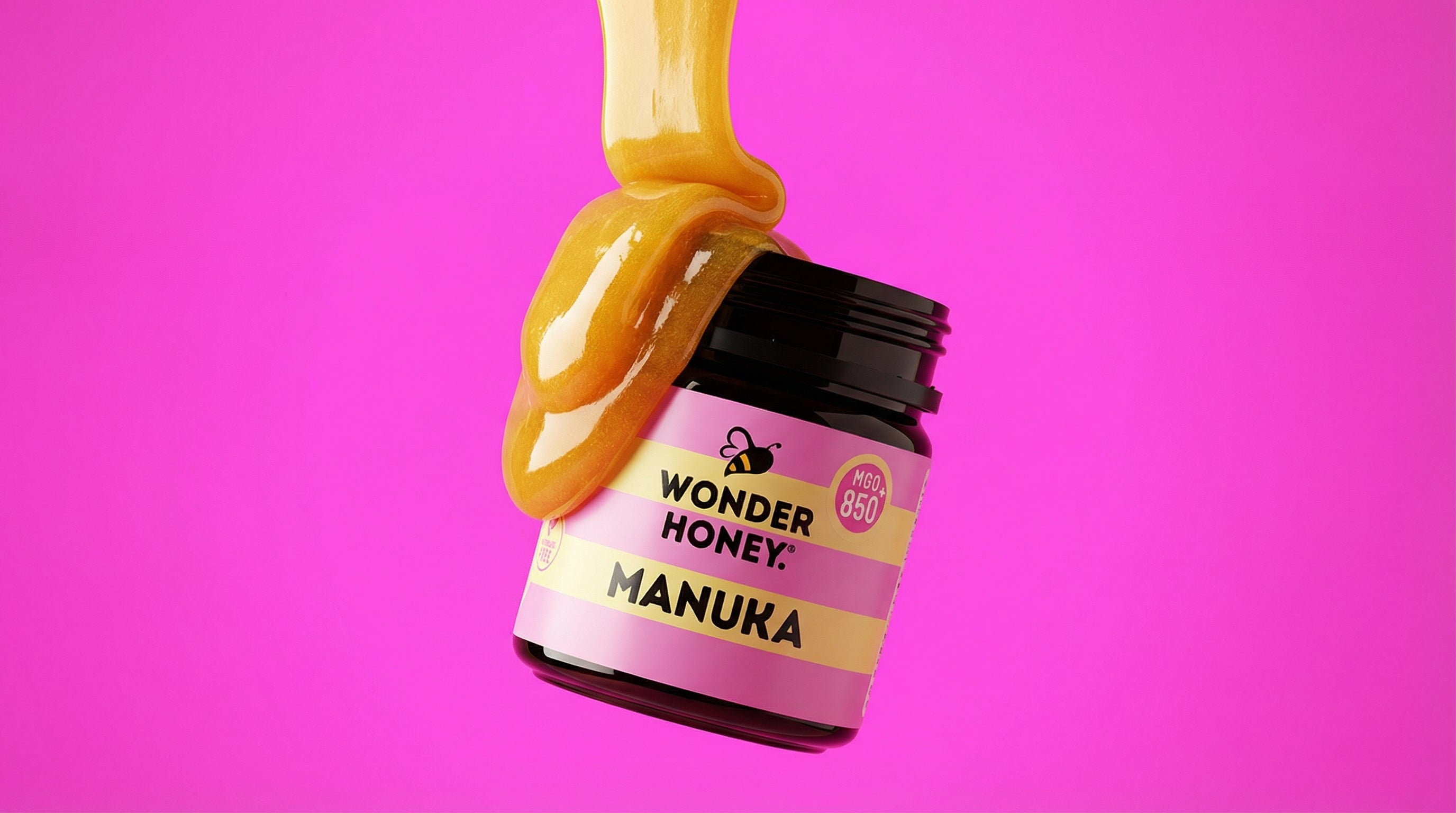 Jar of Wonder Honey Manuka honey with a pink label on a pink background